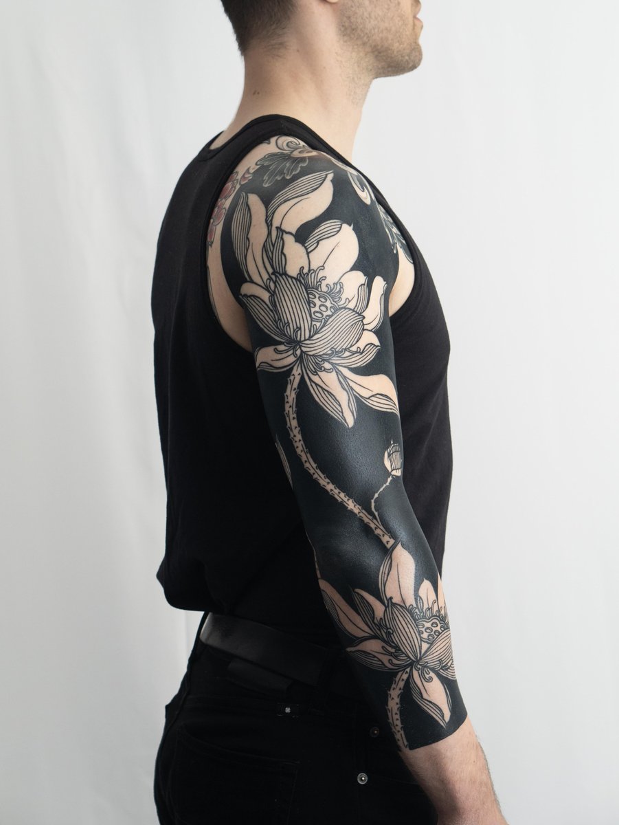 Photo of the tattoo titled Healed Lotus Flowers Blackout Arm